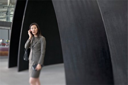 simsearch:700-05821725,k - Businesswoman Talking on Cell Phone in Airport Stock Photo - Rights-Managed, Code: 700-05821757