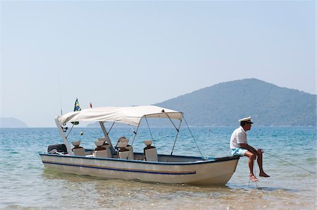 Mann, sitzend auf Boot, in der Nähe von Paraty, Rio De Janeiro, Brasilien Stockbilder - Lizenzpflichtiges, Bildnummer: 700-05947868