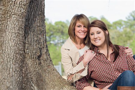 famiglia adulta - Portrait of Mother and Daughter Sitting by Tree Fotografie stock - Rights-Managed, Codice: 700-06282090