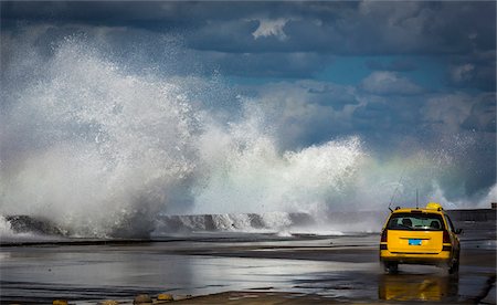 Yellow Car Driving Past Sea Wall with Crashing Waves in the Vedado District of Havana, Cuba Foto de stock - Con derechos protegidos, Código: 700-06531425