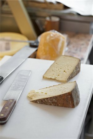 retailer - fresh wedges of French goat cheese in artisan cheese shop with knives on cutting board, La Fromagerie, Paris, France Stock Photo - Rights-Managed, Code: 700-06531963