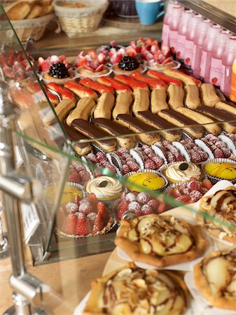 delicious food - assorted sweet pastries and baked goods arranged in rows in glass bakery display case on countertop Foto de stock - Con derechos protegidos, Código: 700-06531980