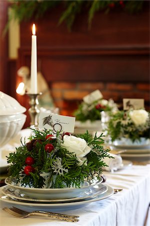 floral Christmas holiday placecard holders with white rose, cedar fronds, and chestnuts in an entertaining tablesetting with a candle Photographie de stock - Rights-Managed, Code: 700-06532022