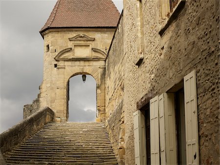 stone stairs leading to archway, with grey cloudy sky, old medieval stone architecture in the small village of Saint-Antoine-l'Abbaye, France Stockbilder - Lizenzpflichtiges, Bildnummer: 700-06543490