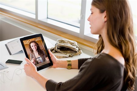 plaudern - Woman in library using a tablet computer to have a video chat with her friend Stockbilder - Lizenzpflichtiges, Bildnummer: 700-06553291