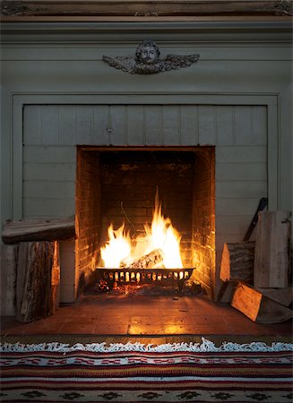 view of fireplace with roaring fire and firewood Stock Photo - Rights-Managed, Code: 700-06570970