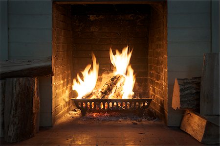 view of fireplace with roaring fire and firewood Stock Photo - Rights-Managed, Code: 700-06570971
