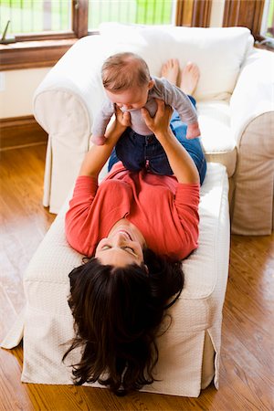 Woman Lying Down and Holding Three Month Old Son Up in Air Stockbilder - Lizenzpflichtiges, Bildnummer: 700-06645608