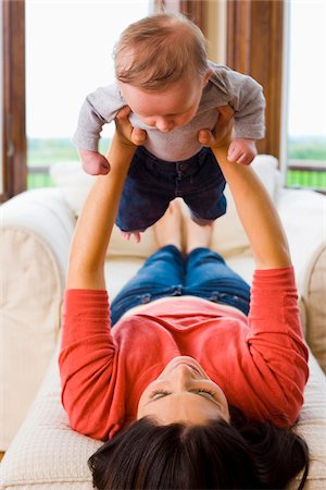 Woman Lying Down and Holding Her Three Month Old Son Up in Air Stockbilder - Lizenzpflichtiges, Bildnummer: 700-06645600