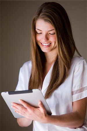 Woman sitting using an ipad. Stock Photo - Rights-Managed, Code: 700-06674974