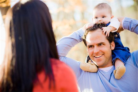 shoulder ride on mom - Man Carrying Four Month Old Daughter on his Shoulders while Talking with Woman, Outdoors at Scanlon Creek Conservation Area, near Bradford, Ontario, Canada Stock Photo - Rights-Managed, Code: 700-06674976