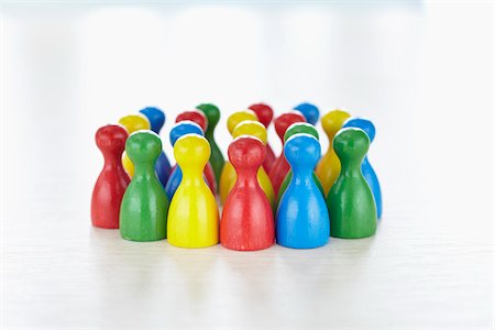 Huddle of multi-colored playing pieces standing together in a group like people Photographie de stock - Rights-Managed, Code: 700-06679362