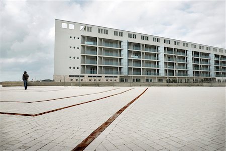 Man in Courtyard of Modern Building on Cloudy Overcast Day, Ostia Lido, Rome, Lazio, Italy Stock Photo - Rights-Managed, Code: 700-06685209