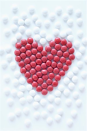 close-up of red pills arranged into heart shape amongst white pills Stockbilder - Lizenzpflichtiges, Bildnummer: 700-06714047