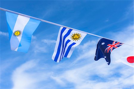 simsearch:700-01195969,k - Uruguayan, Argentinian, Australian, and Japanese flags against blue summer sky Foto de stock - Con derechos protegidos, Código: 700-06752247