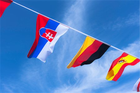 diagonal lines in photography - Slovakian, Spanish, and German flags against blue summer sky Stock Photo - Rights-Managed, Code: 700-06752260