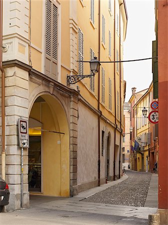 simsearch:700-06773317,k - narrow cobblestone street lined with archways and yellow buildings, Modena, Italy Stock Photo - Rights-Managed, Code: 700-06773316