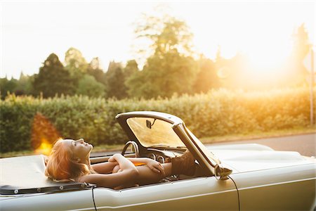 Teenage girl laying back in a 1966 Triumph in Portland Oregon. Stock Photo - Rights-Managed, Code: 700-06786692