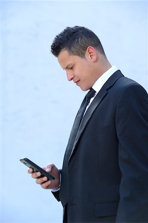 simsearch:700-06701842,k - Close-up of a young businessman looking down at smartphone, Bavaria, Germany Photographie de stock - Rights-Managed, Code: 700-06786885
