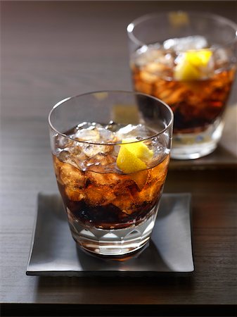 Table with 2 glasses of whisky and cola garnished with lemon Stockbilder - Lizenzpflichtiges, Bildnummer: 700-06895092