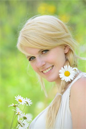 spring young woman - Portrait of a blond woman with a oxeye daisy flower in her hair, Germany Photographie de stock - Rights-Managed, Code: 700-06899970