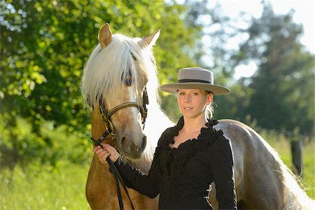 equestrian woman - Young woman standing beside a Connemara horse stallion on a meadow, Germany Stock Photo - Rights-Managed, Code: 700-06900031