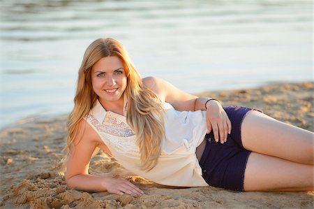 david & micha sheldon - Young woman lying on a sandy beach at the shore of a lake, Germany Foto de stock - Con derechos protegidos, Código: 700-06939626