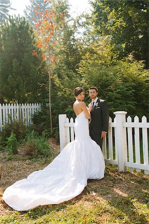 simsearch:700-05786594,k - Bride and Groom standing outdoors next to fence on Wedding Day, looking at camera Stockbilder - Lizenzpflichtiges, Bildnummer: 700-06939707