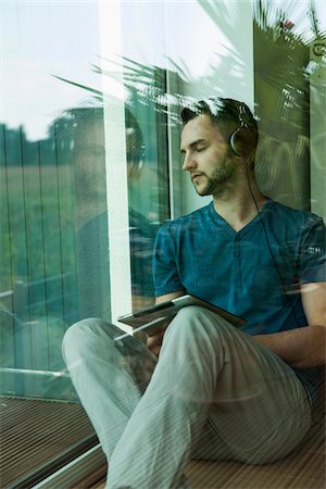 reflektion - Young Man Listening to Music through Headphones at Home, Mannheim, Baeden-Wurttemberg, Germany Stockbilder - Lizenzpflichtiges, Bildnummer: 700-06962021