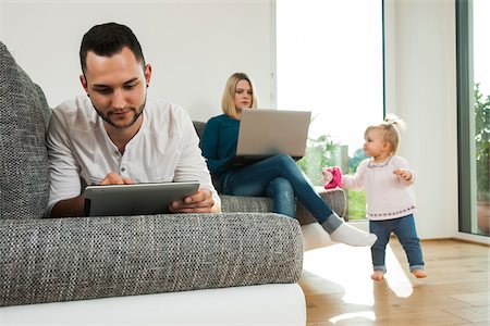 family tablet pc - Family Relaxing in Living Room at Home, Mannheim, Baden-Wurttemberg, Germany Photographie de stock - Rights-Managed, Code: 700-06962032