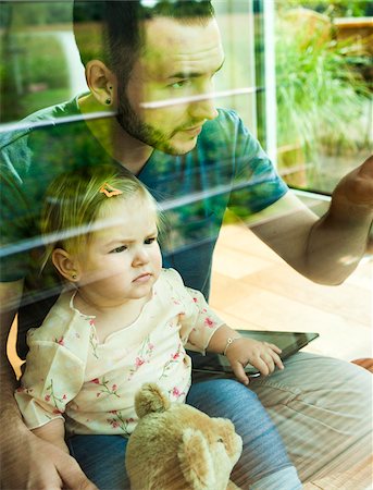 simsearch:700-06962036,k - Baby Girl sitting on Father's Lap at Home, Mannheim, Baden-Wurttemberg, Germany Foto de stock - Con derechos protegidos, Código: 700-06962063