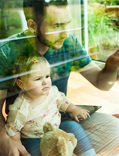 Baby Girl sitting on Father's Lap at Home, Mannheim, Baden-Wurttemberg, Germany Stock Photo - Premium Rights-Managed, Artist: Uwe Umstätter, Image code: 700-06962063