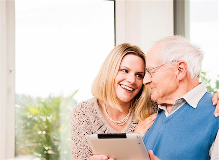 father and adult child - Young Woman and Senior Man using Tablet Computer at Home, Mannheim, Baden-Wurttemberg, Germany Stock Photo - Rights-Managed, Code: 700-06962199