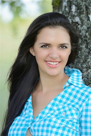 Close-up portrait of young woman standing beside tree, Bavaria, Germany Foto de stock - Con derechos protegidos, Código: 700-07067358