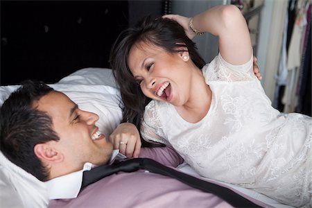 simsearch:700-07203959,k - Close-up of couple laying on bed laughing Foto de stock - Con derechos protegidos, Código: 700-07062774