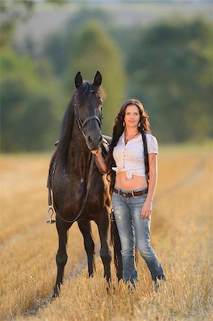 david & micha sheldon - Portrait of young woman standing beside a Friesian horse in a cut cornfield, Bavaria, Germany Photographie de stock - Rights-Managed, Code: 700-07080474