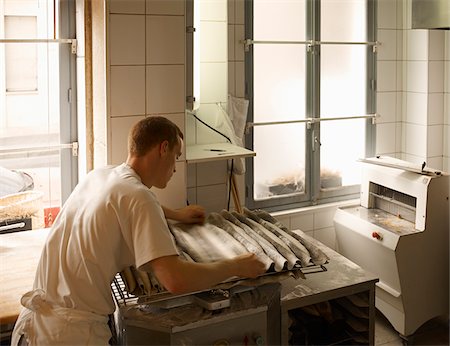 fait à la main - Male baker shaping baguette bread dough by hand in bakery, Le Boulanger des Invalides, Paris, France Photographie de stock - Rights-Managed, Code: 700-07156239