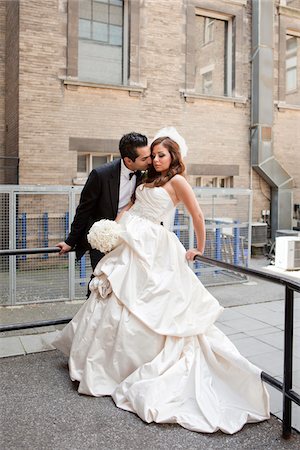 Groom kissing bride outdoors next to buildings, Toronto, Ontario, Canada Stockbilder - Lizenzpflichtiges, Bildnummer: 700-07199834