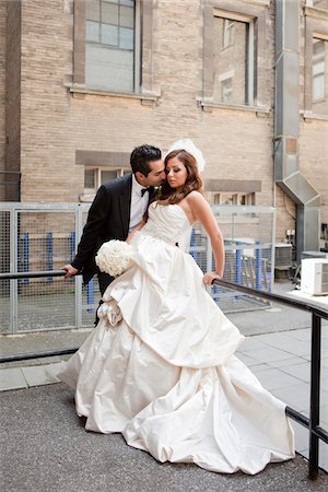 simsearch:700-07203959,k - Groom kissing bride outdoors next to buildings, Toronto, Ontario, Canada Foto de stock - Con derechos protegidos, Código: 700-07199834