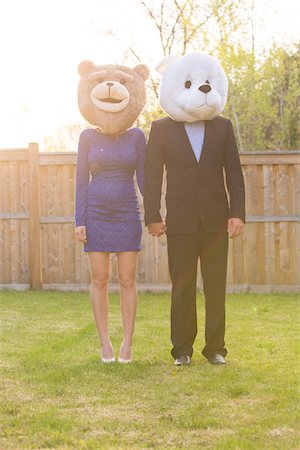 Portrait of couple standing in backyard dressed in formal attire, covering faces wearing costume bear heads, Canada Stockbilder - Lizenzpflichtiges, Bildnummer: 700-07237604