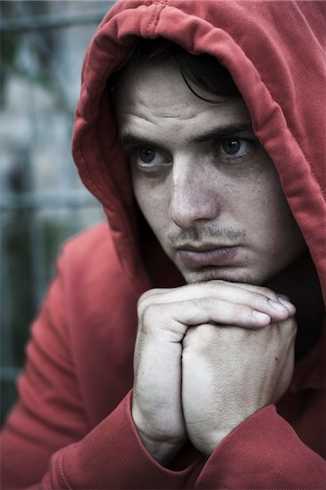Close-up portrait of young man outdoors wearing red hoodie, looking upset, Germany Stock Photo - Premium Rights-Managed, Artist: Uwe Umstätter, Image code: 700-07237994