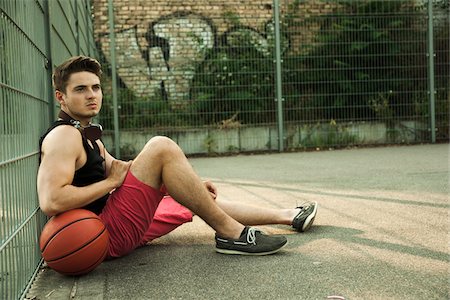 simsearch:600-06899940,k - Portrait of young man sitting on ground with bsketball, at fenced-in basketball court, Germany Foto de stock - Con derechos protegidos, Código: 700-07237991