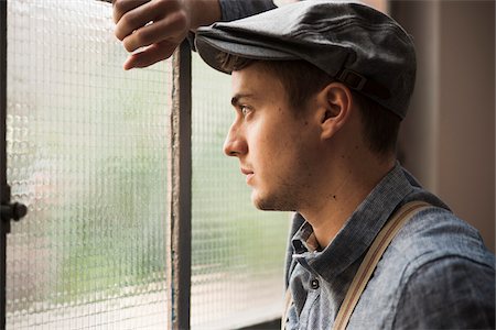 side (the side of) - Portrait of Young Man Looking out Window, Mannheim, Baden-Wurttemberg, Germany Foto de stock - Con derechos protegidos, Código: 700-07238132