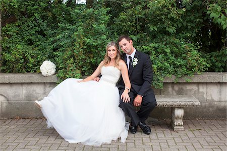 Portrait of Bride and Groom sitting on stone bench outdoors on Wedding Day, smiling and looking at camera, Canada Photographie de stock - Rights-Managed, Code: 700-07232329