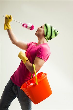 Young man having fun with colorful cleaning supplies, studio shot on white background Stockbilder - Lizenzpflichtiges, Bildnummer: 700-07278874