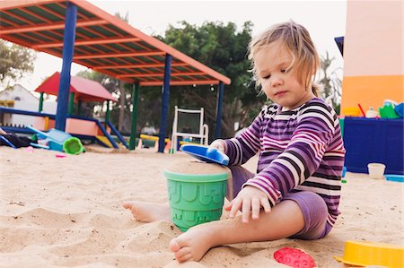 Three year old girl playing in playground with a shovel and bucket in sand, Spain Stock Photo - Rights-Managed, Code: 700-07311136