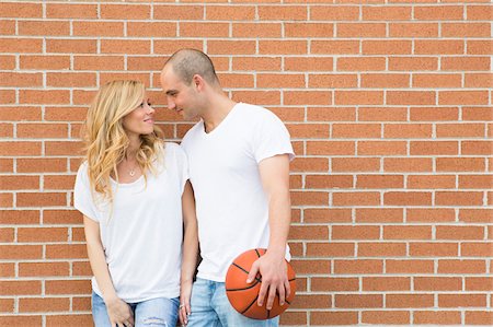 Couple with Basketball by Brick Wall Foto de stock - Con derechos protegidos, Código: 700-07311367