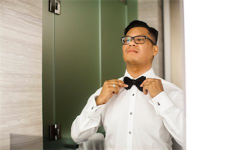 simsearch:700-08059988,k - Portrait of Groom tying Bowtie before Wedding Foto de stock - Con derechos protegidos, Código: 700-07363838