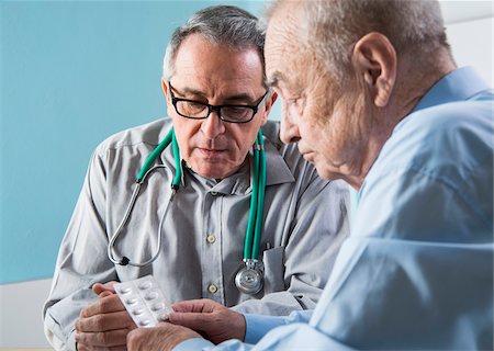 physician with older male - Senior, male doctor conferring with senior, male patient in office, discussing medication, Germany Stock Photo - Rights-Managed, Code: 700-07529234