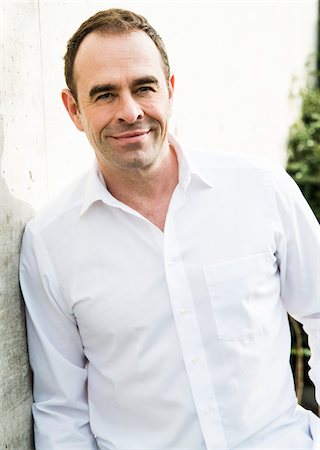 portrait man 40 years - Portrait of man wearing white dress shirt outdoors, smiling and looking at camera, Germany Foto de stock - Con derechos protegidos, Código: 700-07529281